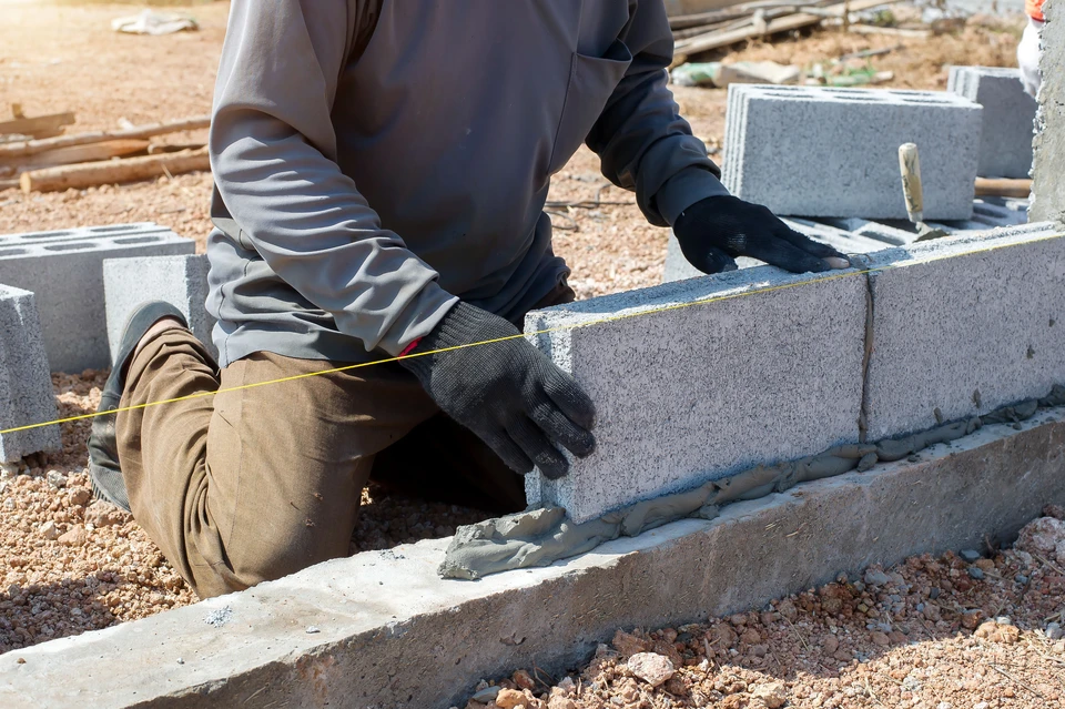 Ouvrier du bâtiment en équipement de sécurité observant un chantier de construction résidentielle