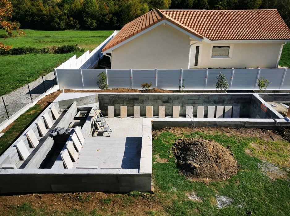 Vue aérienne d'un chantier de construction de piscine en béton armé, en phase de finition