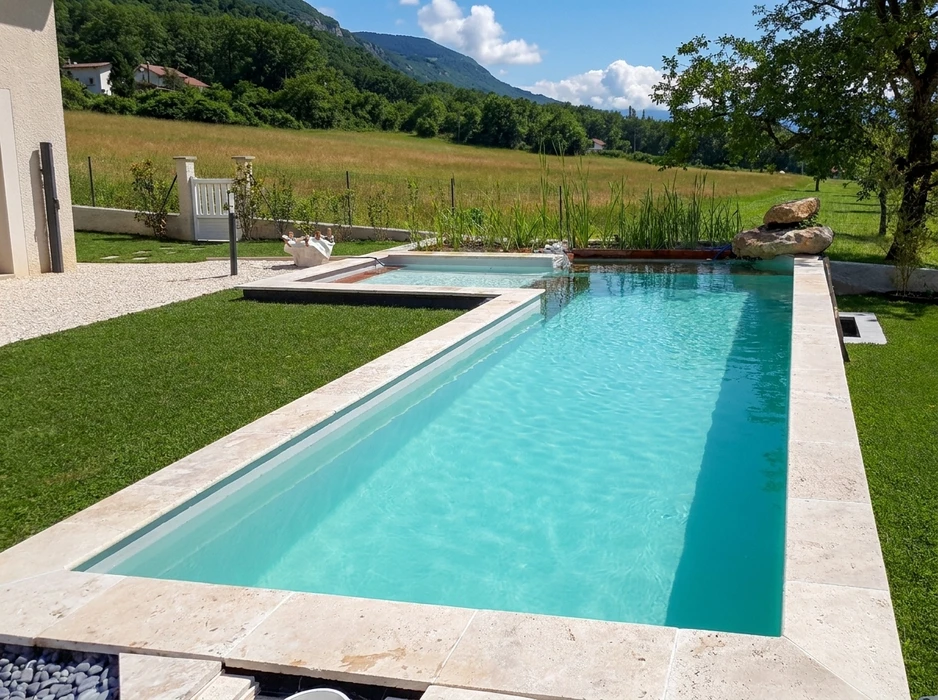Piscine à débordement rectangulaire de type lap pool, entourée d'un dallage en travertin beige